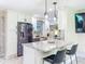 Bright, updated kitchen with stainless steel appliances, a spacious island, modern lighting, and stylish white cabinetry at 7211 Red Oak Loop, New Port Richey, FL 34654