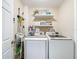 Well-organized laundry area with modern appliances, open shelving, and storage solutions at 7211 Red Oak Loop, New Port Richey, FL 34654
