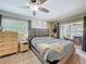 Cozy main bedroom with ceiling fan, window, and sliding glass doors leading to outdoor space at 7211 Red Oak Loop, New Port Richey, FL 34654