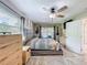 Sun-lit main bedroom with sliding doors to pool, a ceiling fan, and closet access at 7211 Red Oak Loop, New Port Richey, FL 34654
