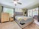 Comfortable main bedroom with ceiling fan, window, and sliding glass doors leading to outdoor space at 7211 Red Oak Loop, New Port Richey, FL 34654