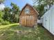 Exterior of wooden shed, featuring large doors and a window, nestled within a lush green lawn at 7211 Red Oak Loop, New Port Richey, FL 34654