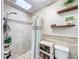 Shower with skylight, tiled walls, and convenient shelves, creating a bright and functional space at 7211 Red Oak Loop, New Port Richey, FL 34654