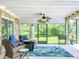 Sunroom sitting area with stone accent wall and views of lush landscaped yard at 7211 Red Oak Loop, New Port Richey, FL 34654