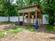 Yard features a wooden framed structure surrounded by greenery, perfect for outdoor enjoyment at 7211 Red Oak Loop, New Port Richey, FL 34654