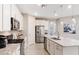 Modern kitchen features white cabinets, granite countertops, stainless steel appliances and stylish pendant lighting at 7621 Highgrove Ave, Bradenton, FL 34210