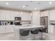 Bright kitchen boasts white cabinetry, granite countertops, stainless steel appliances, and an island with bar stools at 7621 Highgrove Ave, Bradenton, FL 34210