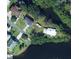 An aerial view showcases the home with waterfront access and lush surrounding greenery at 9107 Brunswick Ln, Tampa, FL 33615