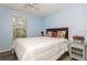 Cozy bedroom with a plush bed, side table and drawers, and natural light from the window at 9107 Brunswick Ln, Tampa, FL 33615