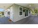 Exterior view of a gray house with a covered deck and ceiling fans for outdoor comfort at 9107 Brunswick Ln, Tampa, FL 33615