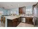 Kitchen featuring stainless steel appliances, dark cabinets, and a view to the dining area at 9107 Brunswick Ln, Tampa, FL 33615