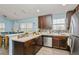 Well-equipped kitchen with wood cabinets, stainless steel appliances, and a breakfast bar at 9107 Brunswick Ln, Tampa, FL 33615