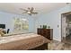 Comfortable bedroom showcasing wood-look flooring, closet, dresser and a large window at 9107 Brunswick Ln, Tampa, FL 33615