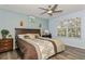 Cozy main bedroom featuring a ceiling fan, light blue walls, and a large window at 9107 Brunswick Ln, Tampa, FL 33615