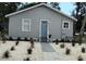 Charming single-story home with a light blue door and tidy landscaping at 921 Grand Central St, Clearwater, FL 33756
