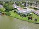 Waterfront home with screened pool, lush landscaping, well-maintained lawn and private dock on a sunny day at 9619 Towanda Ln, Port Richey, FL 34668