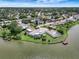 Waterfront home featuring a screened pool, a private dock and lush landscaping on a sunny day at 9619 Towanda Ln, Port Richey, FL 34668