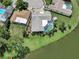 Waterfront home with screened pool, lush landscaping, well-maintained lawn and a small storage shed at 9619 Towanda Ln, Port Richey, FL 34668