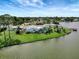 Waterfront home featuring a screened pool, a private dock and lush landscaping on a sunny day at 9619 Towanda Ln, Port Richey, FL 34668