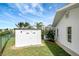 Side yard featuring a storage shed, landscaping and lake view at 9619 Towanda Ln, Port Richey, FL 34668