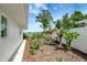 Backyard showcasing tropical landscaping and peaceful lake view at 9619 Towanda Ln, Port Richey, FL 34668