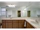 Bright bathroom with double sinks, wooden cabinets, and a large mirror covering the entire wall at 9619 Towanda Ln, Port Richey, FL 34668