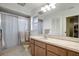 Bathroom showcasing a white countertop, shower with glass doors, and a toilet, lit by a modern light fixture at 9619 Towanda Ln, Port Richey, FL 34668