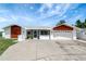 Charming home featuring a two-car garage, patterned wood siding, and a screened front entry at 9619 Towanda Ln, Port Richey, FL 34668