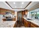 Well-equipped kitchen with stainless steel refrigerator, range, and wood cabinets and granite counters at 9619 Towanda Ln, Port Richey, FL 34668