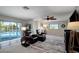 An inviting living room with recliners, ceiling fan, large patterned rug and sliding glass doors to the pool at 9619 Towanda Ln, Port Richey, FL 34668