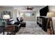 An airy living room features two recliners, a ceiling fan, a large rug, and a flat screen television at 9619 Towanda Ln, Port Richey, FL 34668