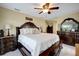 Spacious main bedroom featuring a ceiling fan and complementing dark wood furniture set at 9619 Towanda Ln, Port Richey, FL 34668
