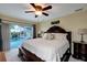 Main bedroom with a ceiling fan, carpet, large bed and dark furniture, with access to the backyard pool at 9619 Towanda Ln, Port Richey, FL 34668