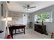 Bright home office with a dark wood desk, ceiling fan, and large window offering natural light at 9619 Towanda Ln, Port Richey, FL 34668