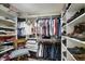 A large walk-in closet with white shelving, offering ample storage space for clothes, shoes, and other items at 9619 Towanda Ln, Port Richey, FL 34668