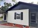 Charming home featuring a black and white exterior and neatly landscaped front yard at 1005 S Empire St, Plant City, FL 33563