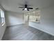 Open-concept living room featuring light gray flooring, neutral walls, and modern ceiling fan at 1005 S Empire St, Plant City, FL 33563