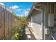 Backyard walkway with mulch garden along the house featuring a stone path and a wooden fence for privacy at 1010 E Fern St, Tampa, FL 33604