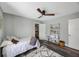 This bedroom boasts a ceiling fan, modern shelving unit, and ample space for relaxing and unwinding at 1010 E Fern St, Tampa, FL 33604
