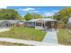 Charming single-story home with a well-maintained front yard, screened in porch, and a covered driveway at 1010 E Fern St, Tampa, FL 33604