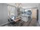 Modern kitchen with updated appliances, white cabinets, and a stylish backsplash visible from the dining room at 1010 E Fern St, Tampa, FL 33604