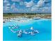 Wide aerial shot featuring the lagoon with a floating obstacle course and inflatable slides at 10747 Laxer Cay Loop, San Antonio, FL 33576