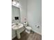 Bathroom with a pedestal sink, wood look tile flooring, and a comfort height toilet at 10864 Banyan Breeze Blvd, Land O Lakes, FL 34638