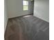 Bright bedroom with neutral carpet, white walls, and a window overlooking the yard at 10864 Banyan Breeze Blvd, Land O Lakes, FL 34638