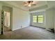 Large primary bedroom with carpet flooring, two large windows, and a ceiling fan at 10864 Banyan Breeze Blvd, Land O Lakes, FL 34638