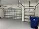 A spacious two-car garage with painted flooring and two garage doors at 10864 Banyan Breeze Blvd, Land O Lakes, FL 34638