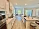 Beautiful white kitchen featuring stainless appliances, a center island, and wood look flooring at 10864 Banyan Breeze Blvd, Land O Lakes, FL 34638