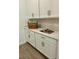 Laundry area with white cabinets, quartz countertop, and wood look flooring at 10864 Banyan Breeze Blvd, Land O Lakes, FL 34638