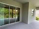 Covered patio featuring a sliding glass door to the house and a view of backyard landscaping at 10864 Banyan Breeze Blvd, Land O Lakes, FL 34638