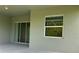 A covered patio featuring a large window and glass sliding door to the interior of the home at 10864 Banyan Breeze Blvd, Land O Lakes, FL 34638